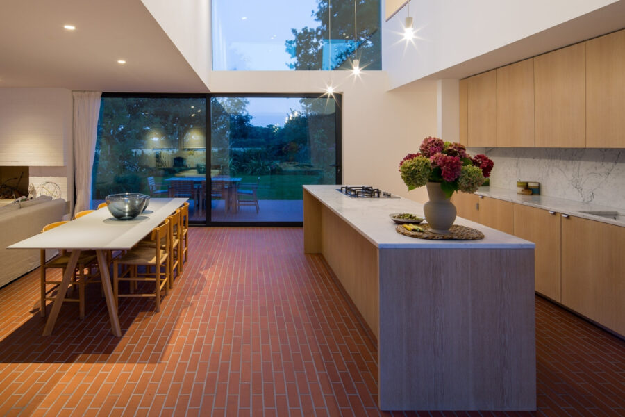 red brick style tiled kitchen flooring with quartz kitchen island